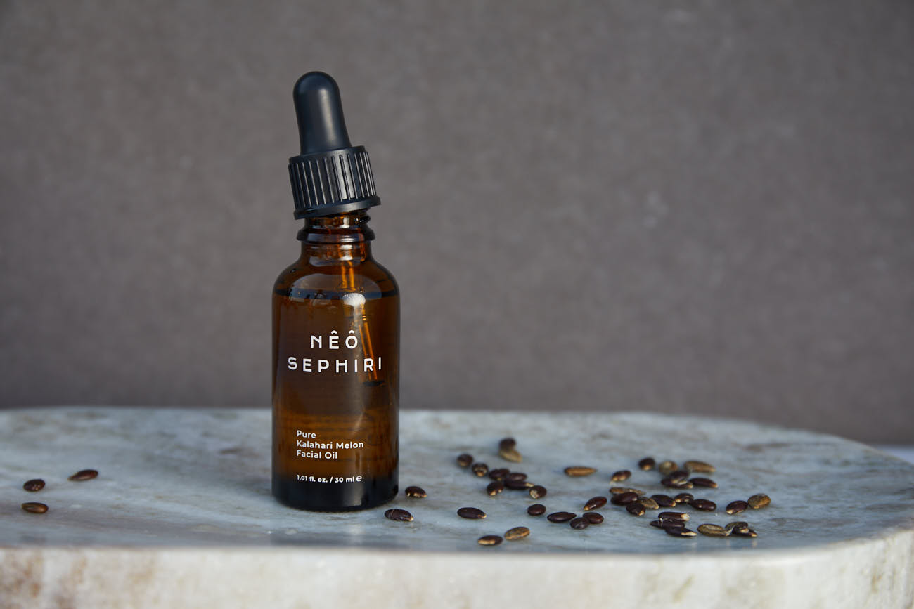 Nêô Sephiri Kalahari Melon Oil on a stone table with Kalahari Melon Seeds