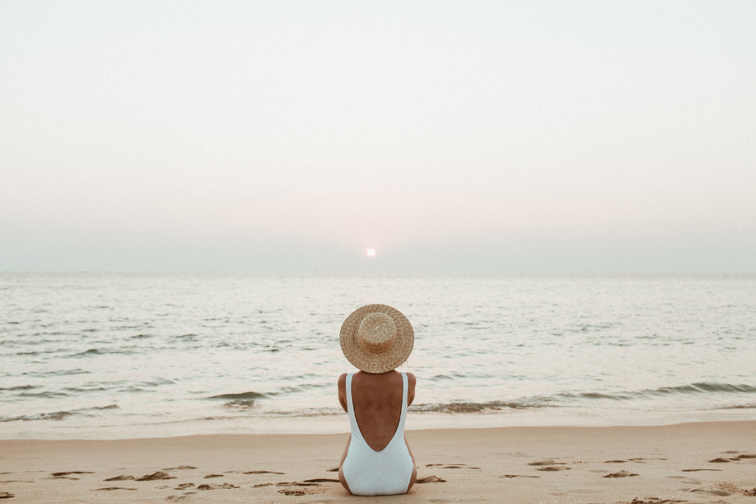 woman on beach facing the sea