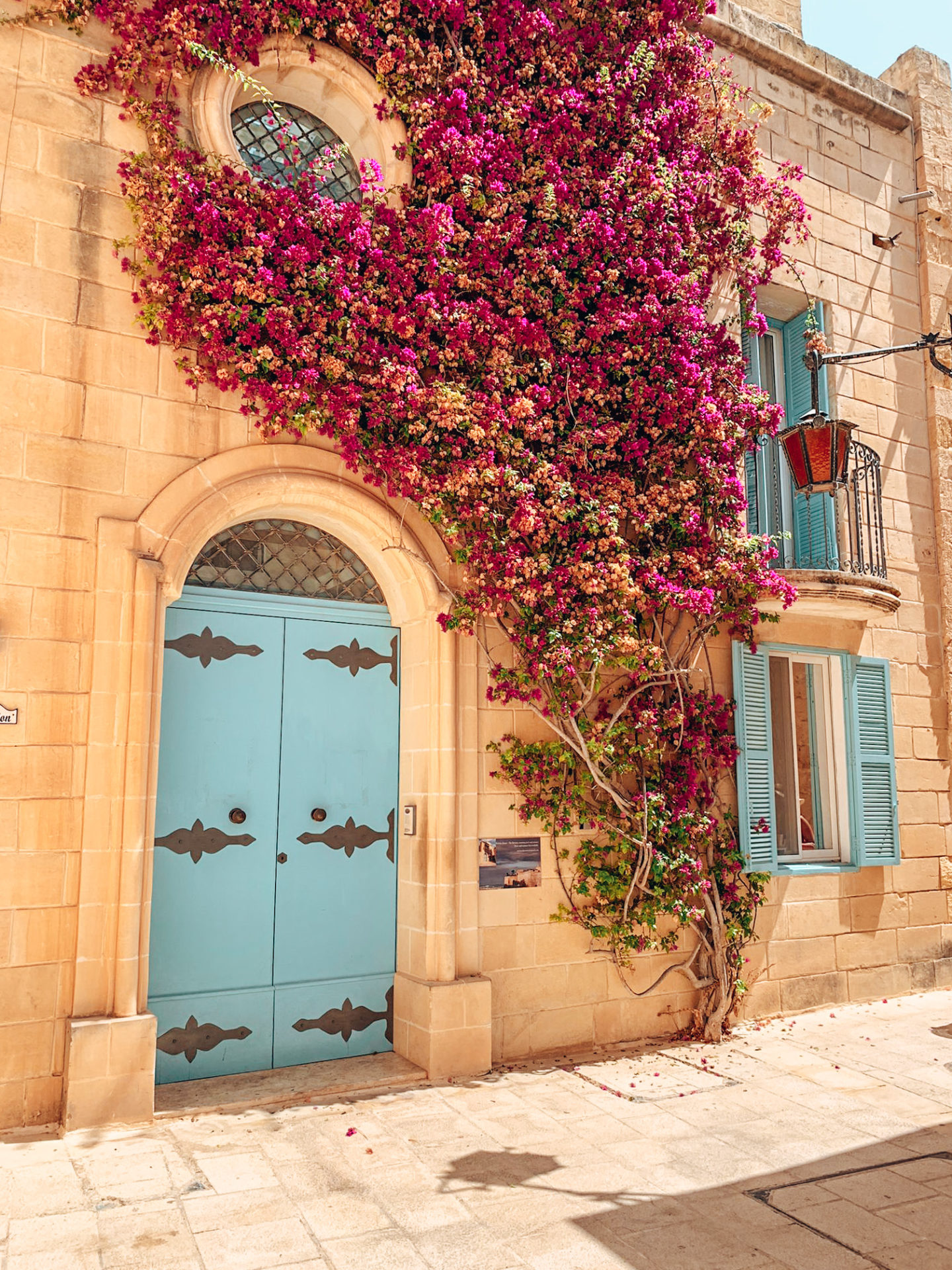 A house in Mdina with a pale blue door and pink bougainvilla