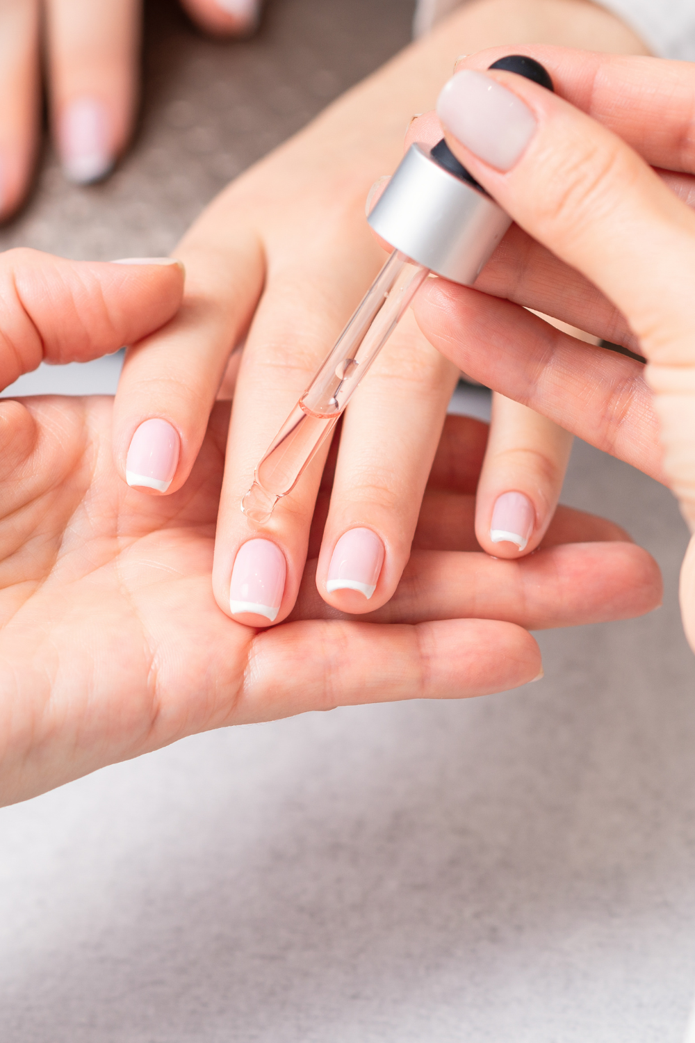 Woman applying cuticle oil as part of a hand care routine