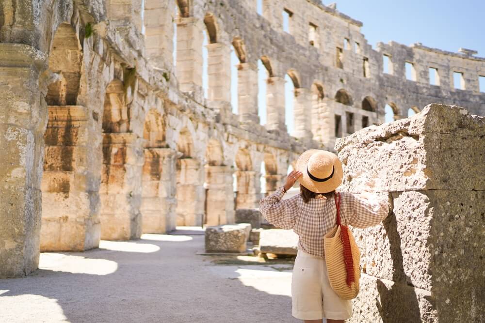 Woman in hat looking at Colosseum in Rome