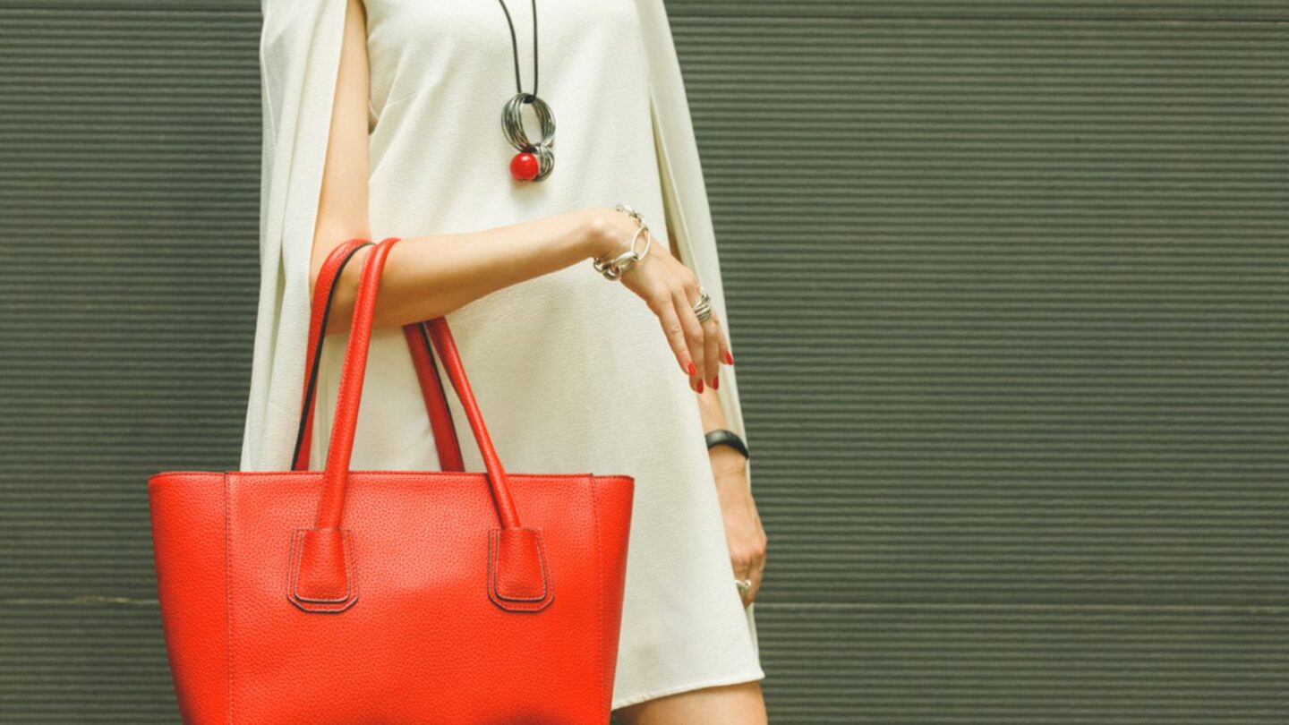 Woman wearing red handbag with white outfit