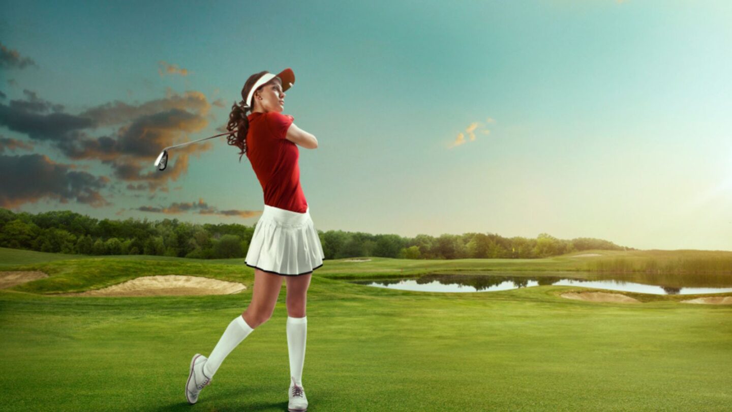 Woman playing golf on a golf course in the sun