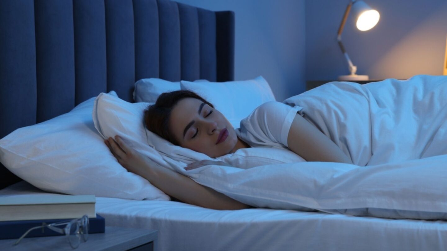 Beautiful young woman sleeping in bed at night