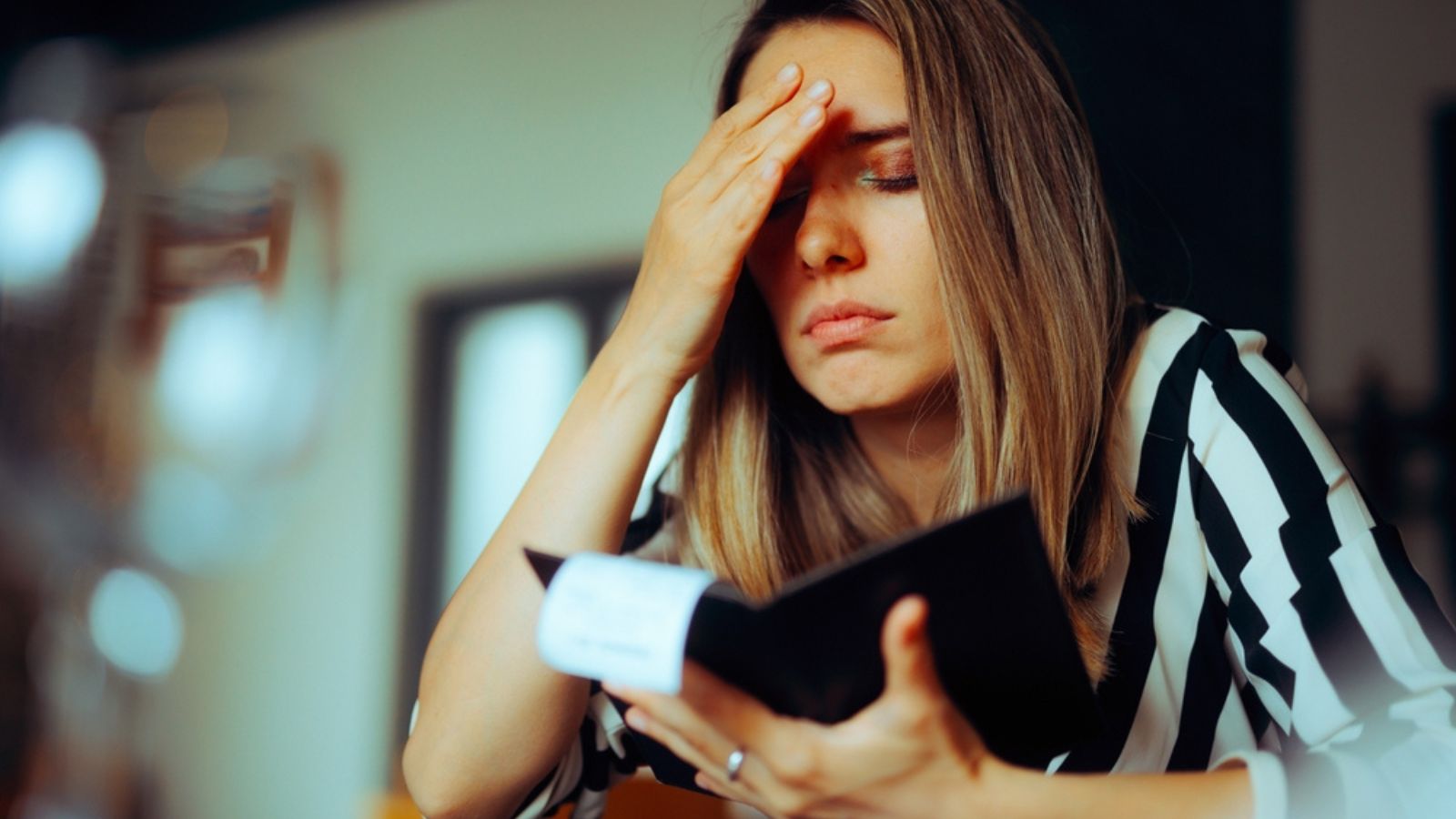 Unhappy Woman Receiving an Overpriced Bill in a Restaurant