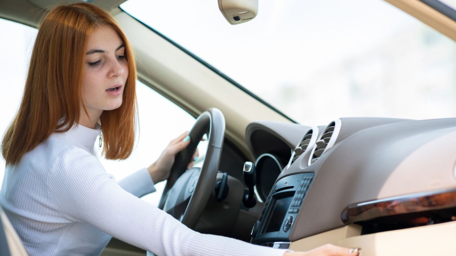 woman driving a car and disctucted while looking for something in glove compartment.